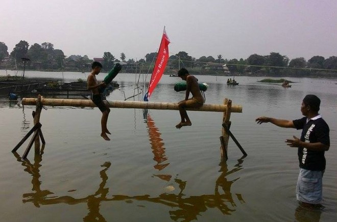 Anak-anak tengah asik mengikuti lomba pukul guling